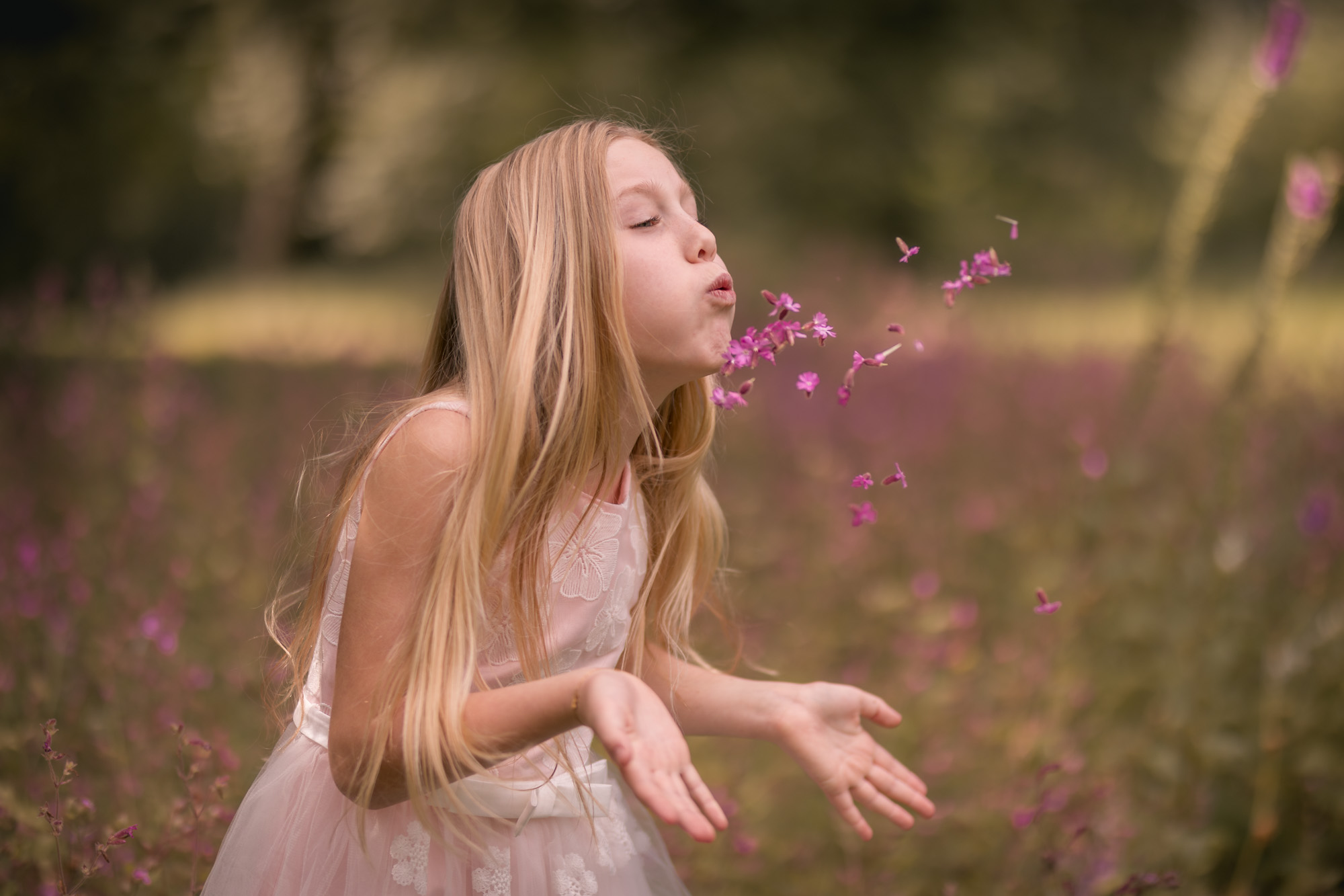 meisje blaast blaadjes weg
